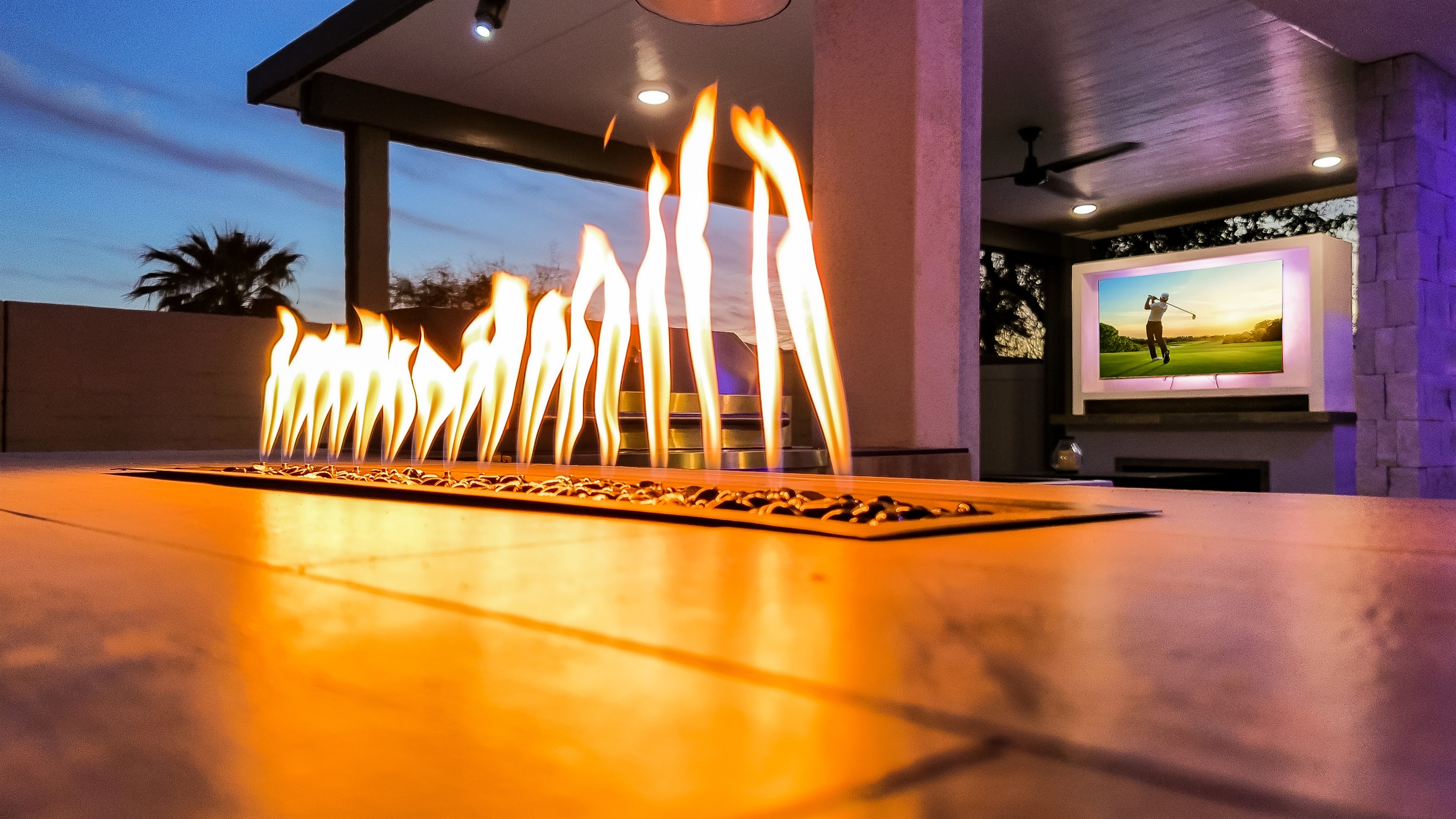 Outdoor island with natural gas BBQ, pizza oven, and tabletop fire feature.