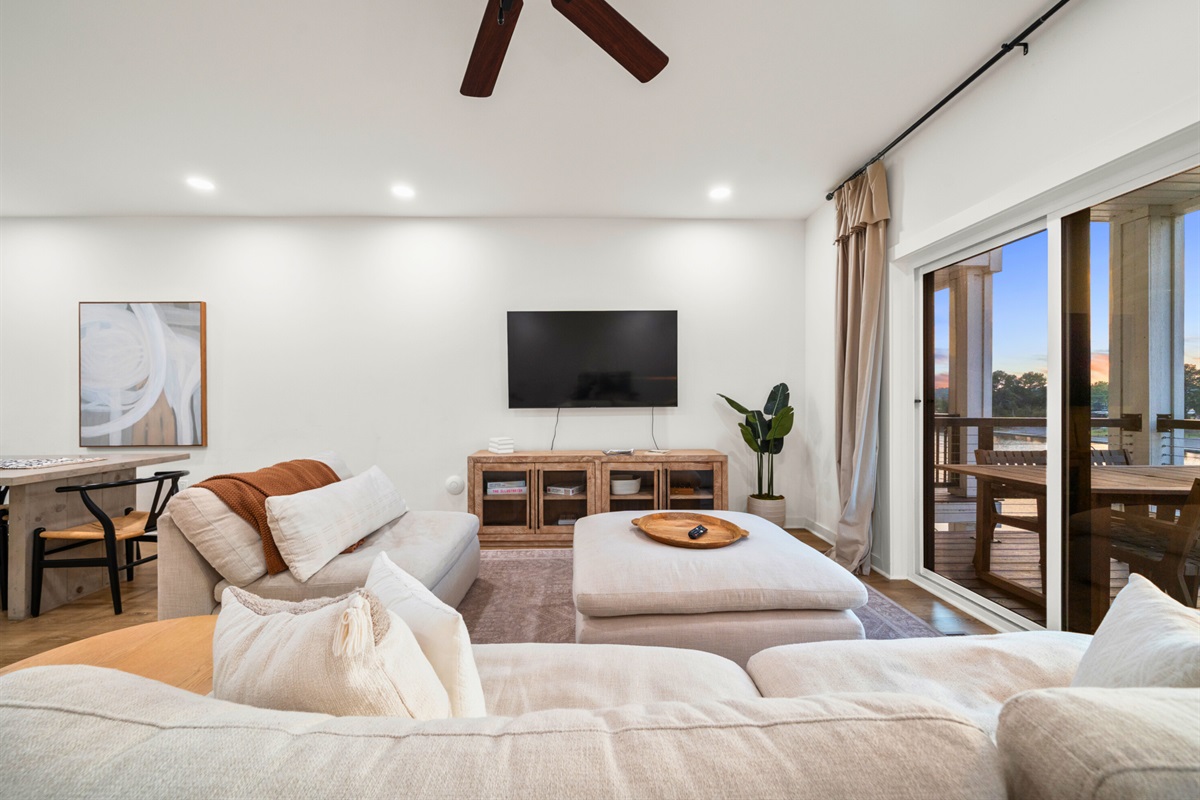 Open living space with sectional sofa, natural light, and direct patio access.