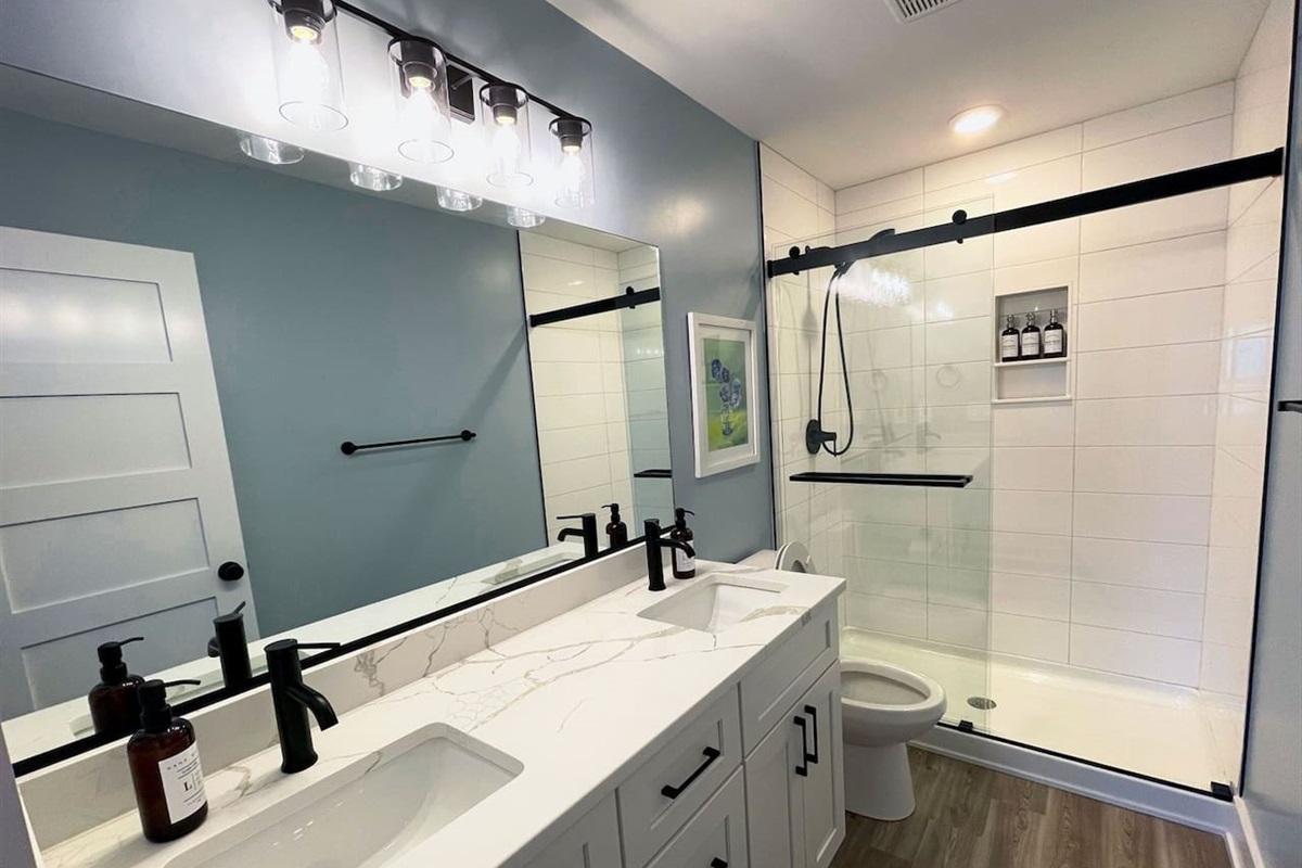 Primary bathroom with double vanity and a beautifully updated walk-in shower.