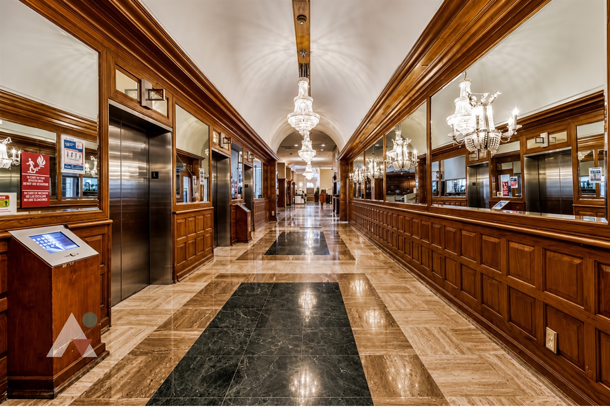 The historic wood-panelled lobby corridor leads to the elevators up to the 16th floor.