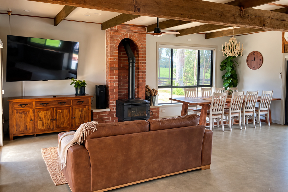 Open-plan lounge, dining, Smart TV and wood fire create a practical shared space for meals, downtime and cooler evenings.
