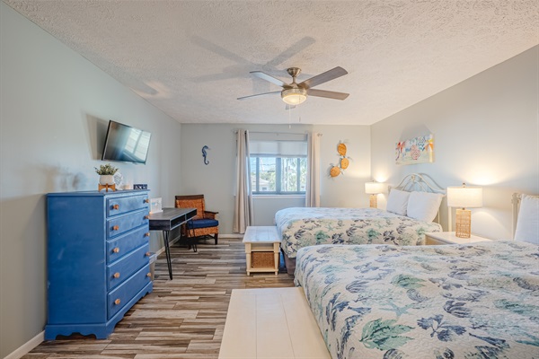 Guest bedroom with two beds, bathroom access, and smart TV