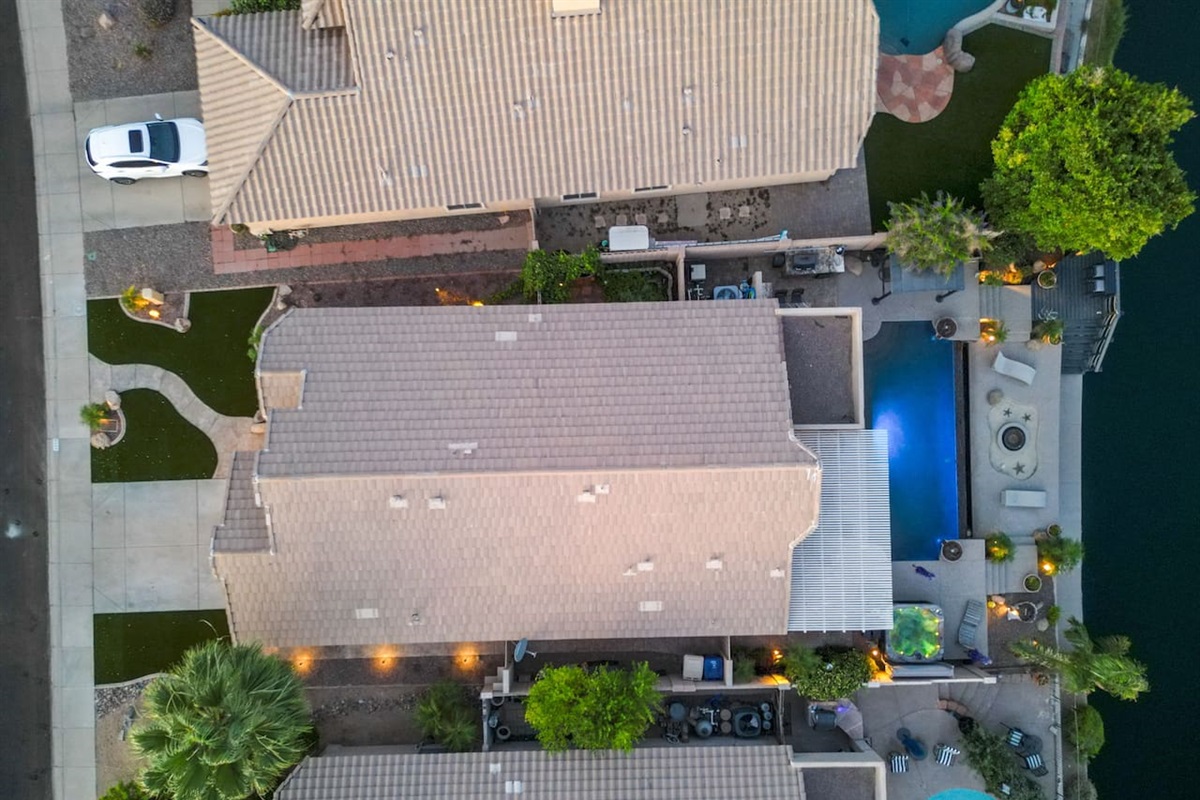 Directly overhead, the layout tells the story — a long private pool, lush landscaping, and lakeside access all contained within your own backyard retreat.
