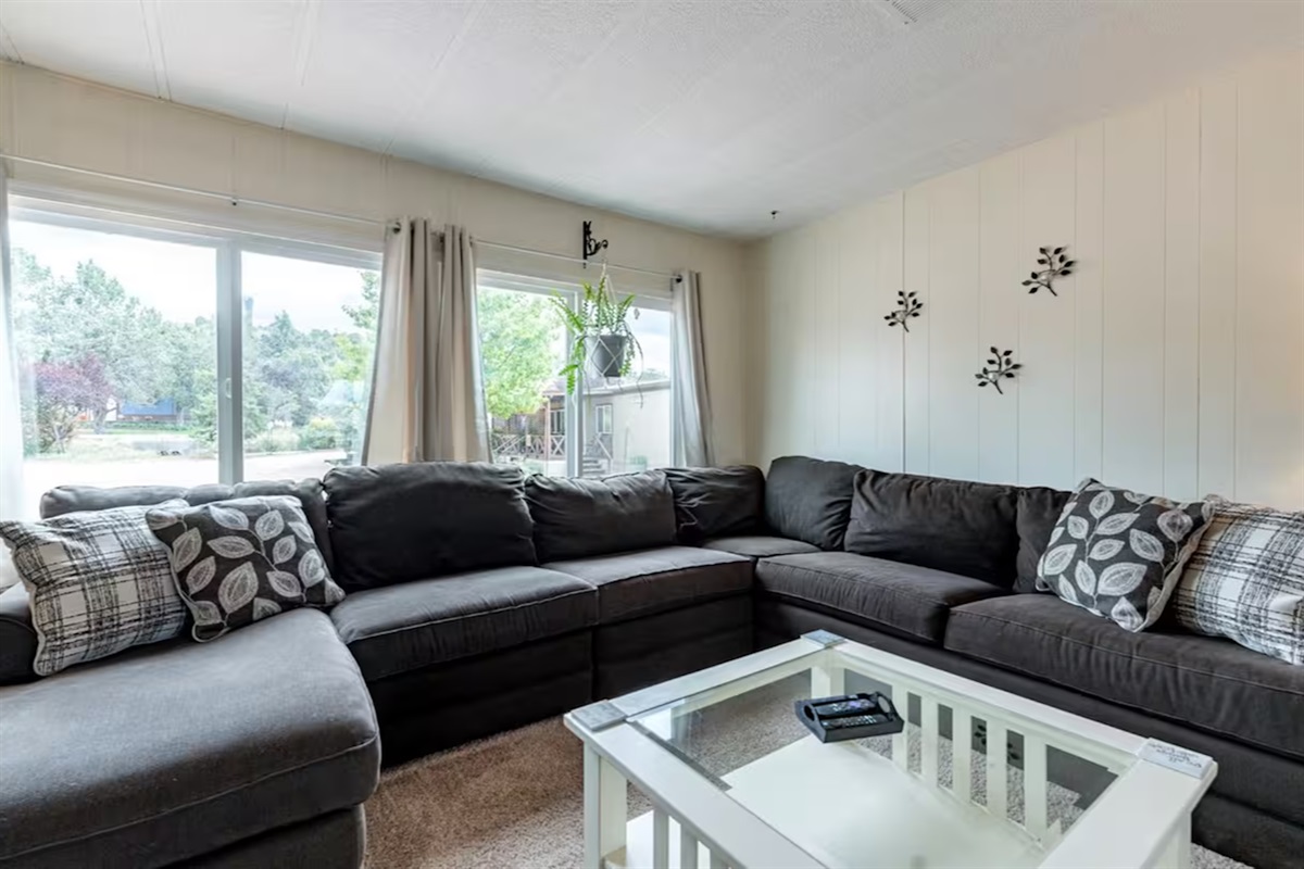 Sunlit family room with comfy sectional, perfect for laughter and relaxation.