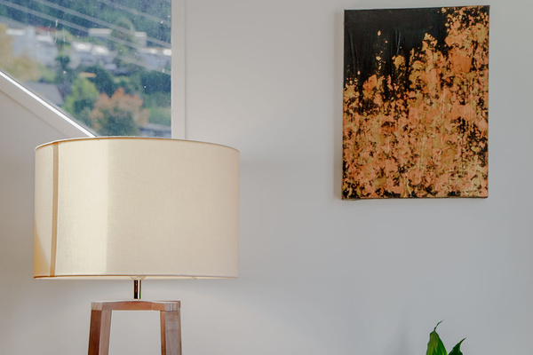 A floor lamp, indoor greenery and wall art give this corner of Fernhill Mountain Escape a calm, finished feel.
