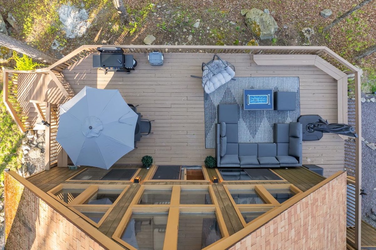 “Expansive deck for outdoor lounging and dining under the trees.”