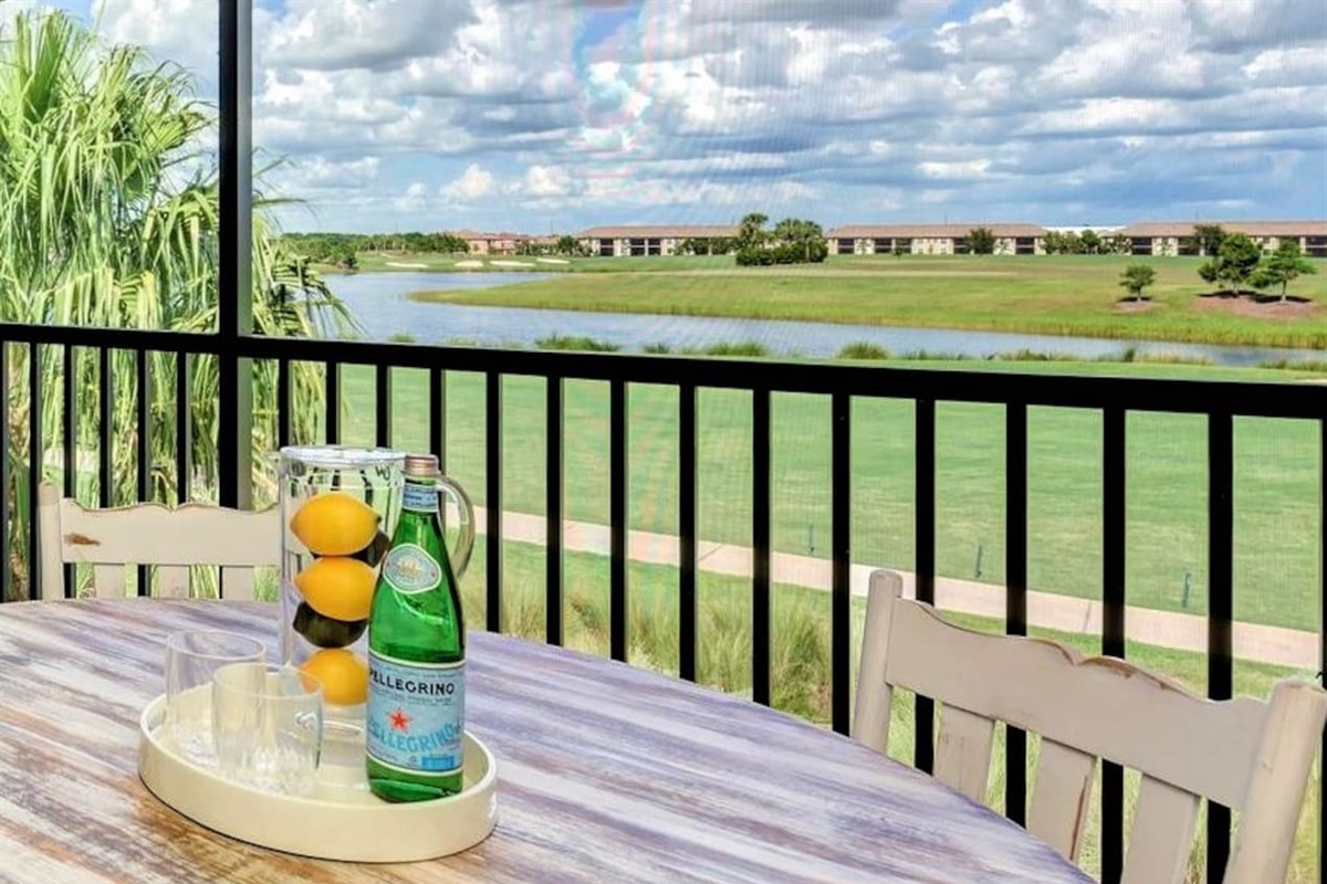 A serene balcony scene overlooking a golf course with palm trees.