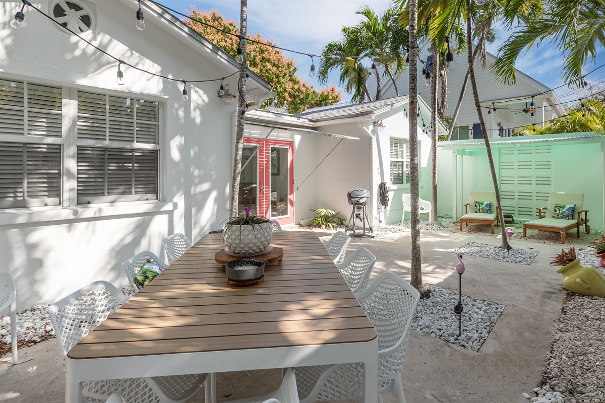 Patio Oasis: Enjoy al fresco dining amid lush greenery and twinkling string lights!