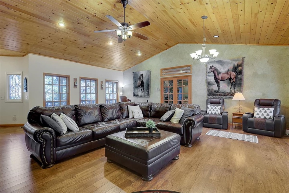 Living room with leather seating, wood ceilings, and plenty of space to gather.

