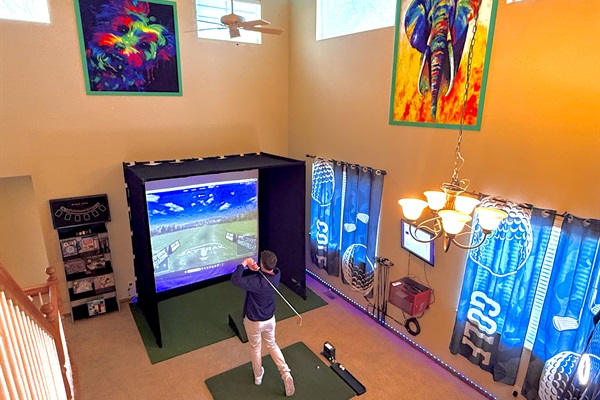 Expansive indoor golf simulator area with a basketball hoop, offering fun and versatility for all your favorite activities