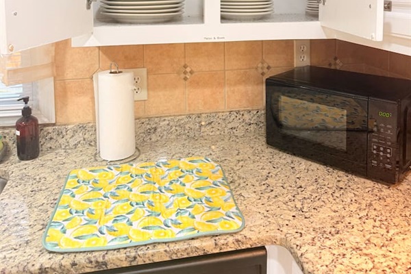Microwave, paper towels, and generous counter space make this kitchen efficient and ready for everyday convenience. 