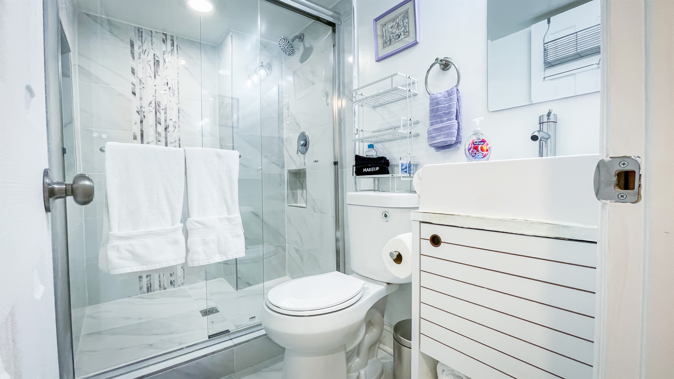 The primary bedroom in the lower level has an en-suite bathroom with a walk-in shower