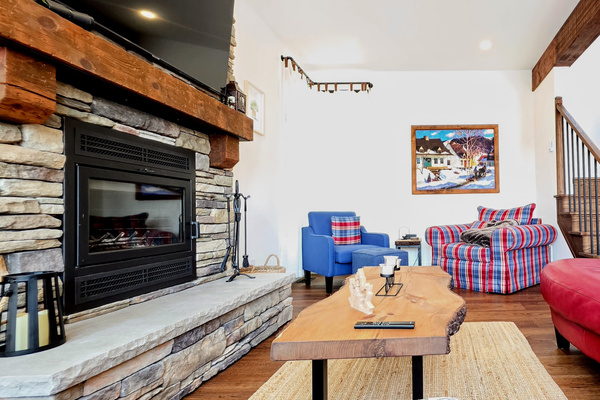 Living room seating showing fireplace and large TV above