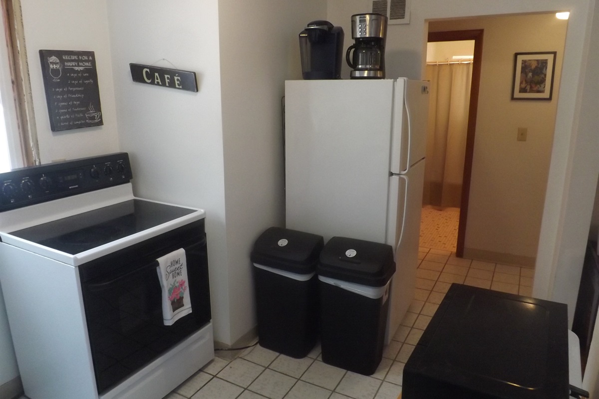 Full kitchen with refrigerator, stove, microwave, coffee makers, and most essentials