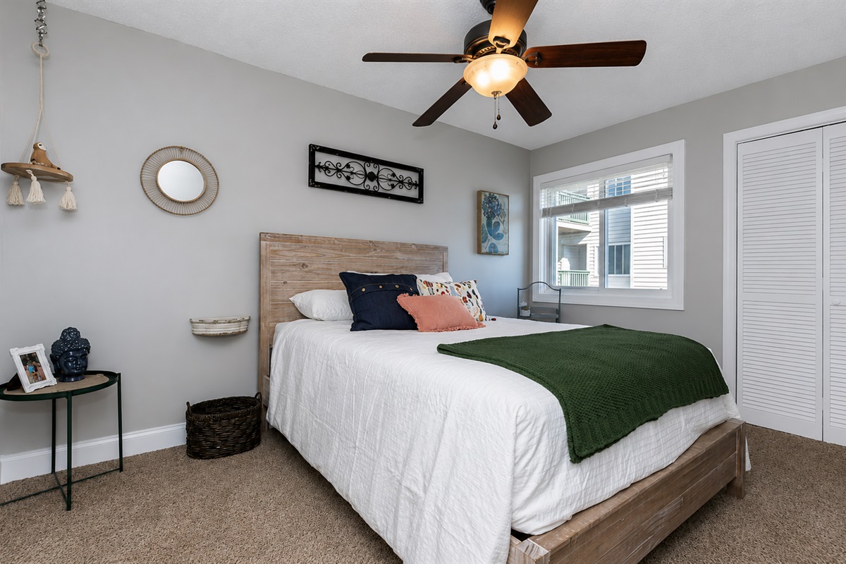 Cozy second bedroom—perfect for family or friends. Queen sized bed with TV and closet. Ceiling fans in all bedrooms for comfort as the unit does not have A/C.