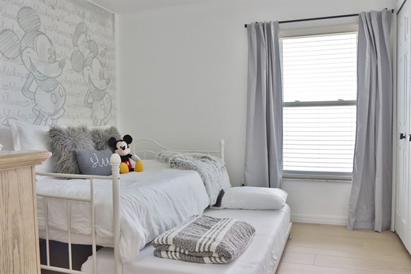 Fun Mickey Mouse themed bedroom with a Full daybed and a Twin trundle bed and black out curtains