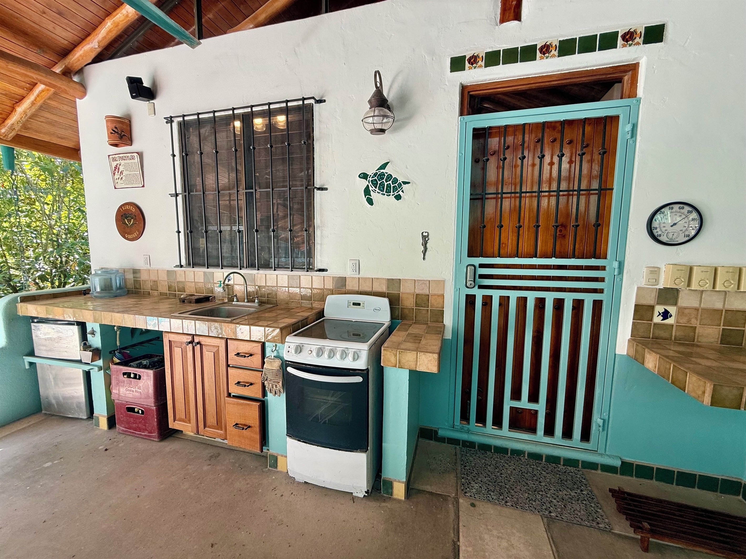 Outdoor kitchen and side entrance to house. Large covered Rancho
