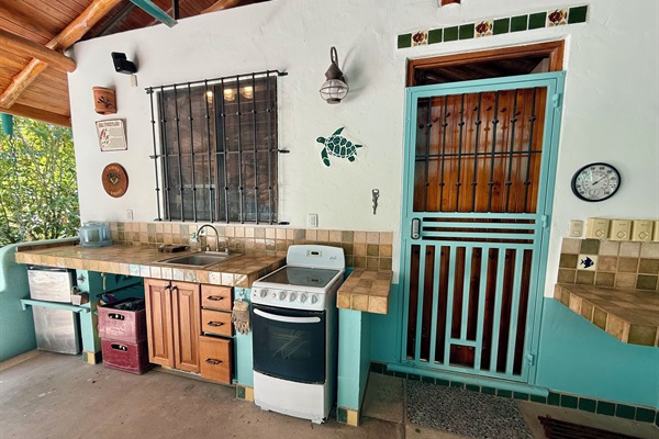 Outdoor kitchen and side entrance to house. Large covered Rancho
