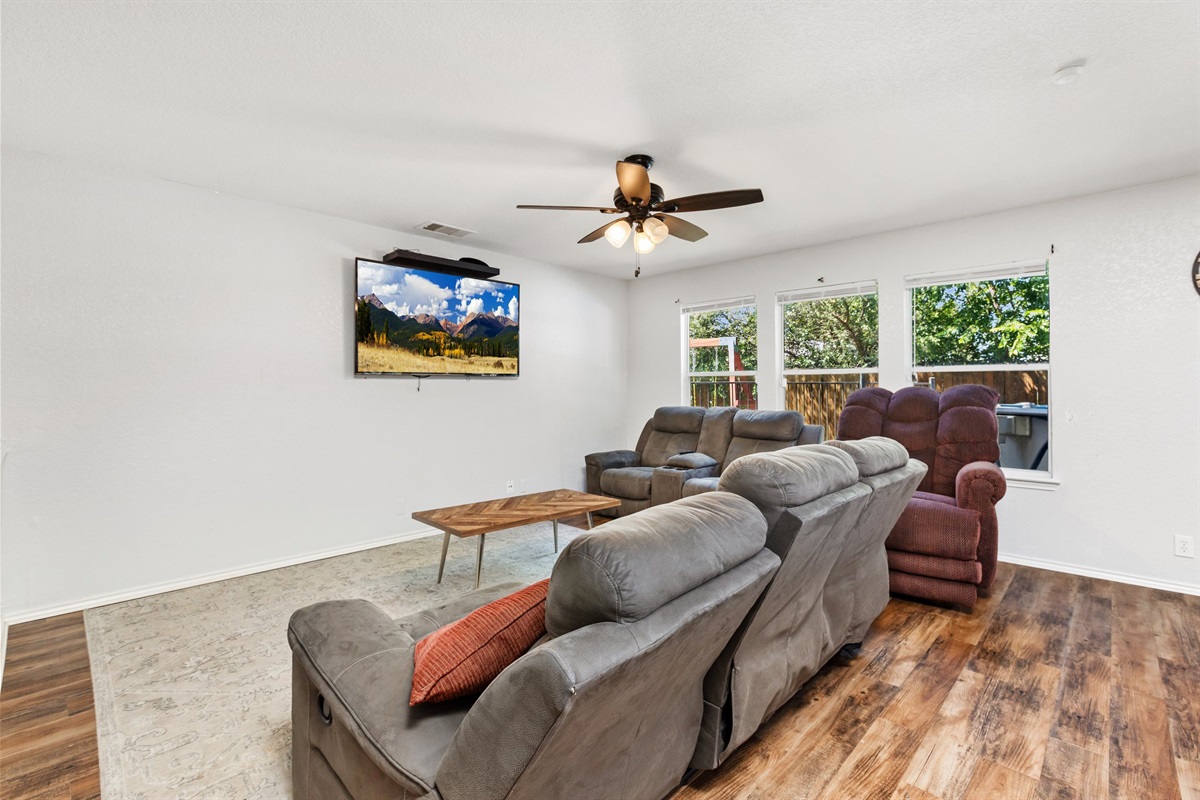 Spacious living room with reclining sectional sofa, hardwood floors, ceiling fan, and Smart TV with Netflix, Hulu, and Disney+. Open layout designed for families and groups of up to 10.