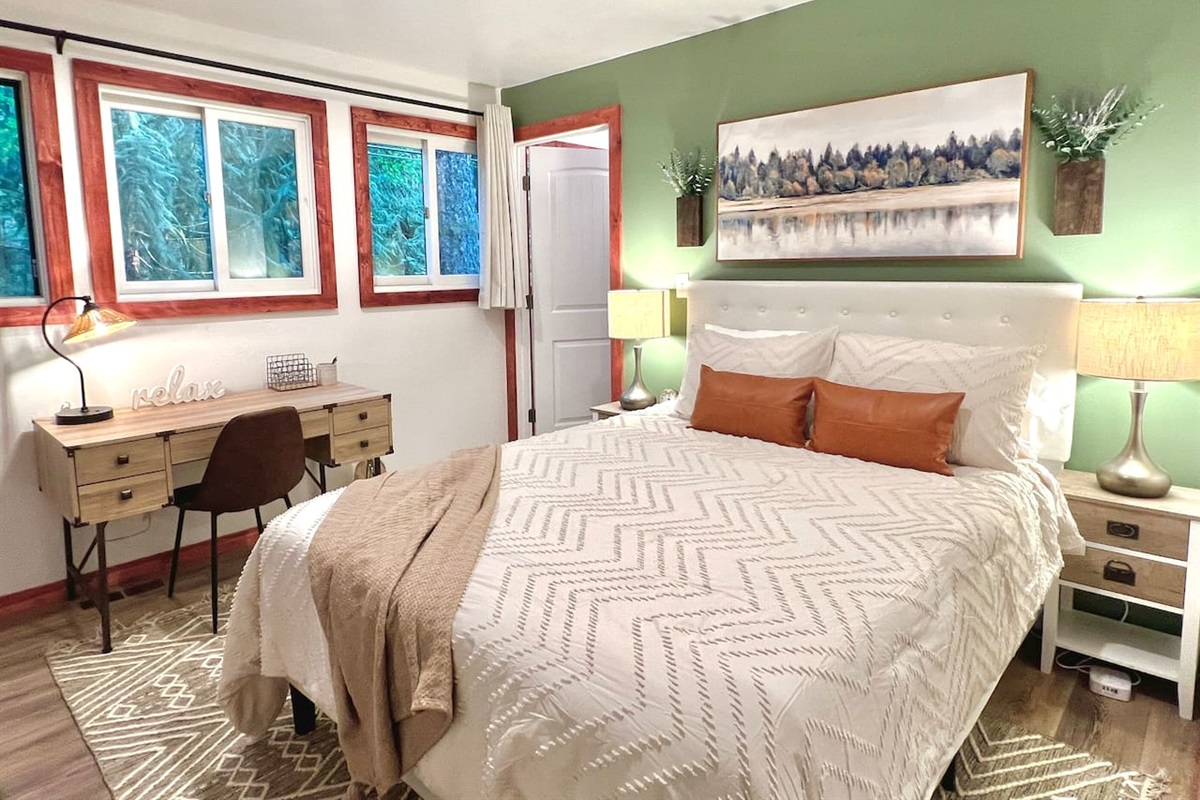 Queen bedroom with on suite bathroom, work desk, and seating area