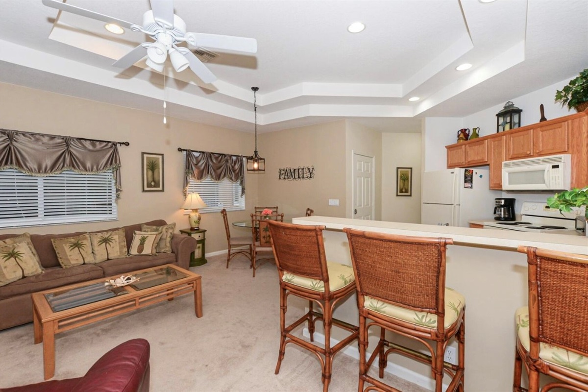 Open-concept living and dining area with high ceilings, comfortable seating, and a bright, welcoming layout.