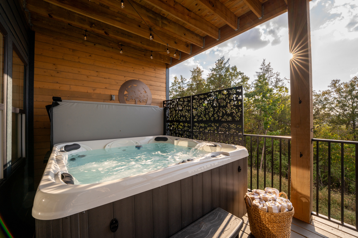 Your private hot tub is ready for long soaks after a day in Branson, tucked beneath the covered deck for added privacy and shade.