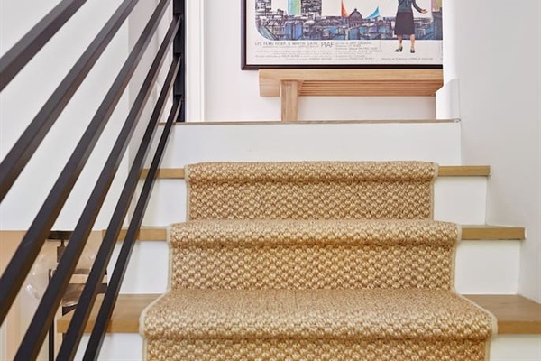 The staircase—located just outside the first-floor king suite and adorned with a beautiful sisal runner—leads to the second-floor king suite and the laundry area, which is equipped with a Miele washer and dryer for your convenience.