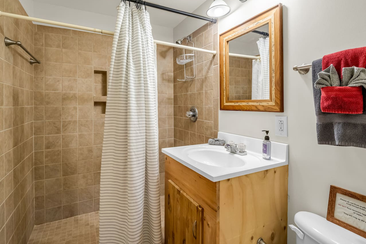 Spacious walk-in tile shower located in the basement-level bathroom, privately accessed by the basement-level bedroom