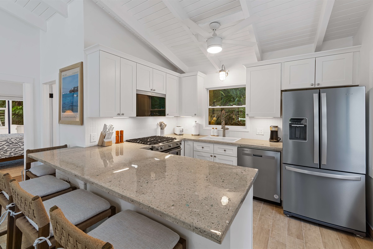 A wide kitchen island here offers plenty of room for guests to pull up a chair and keep the conversation going while the chef prepares a meal