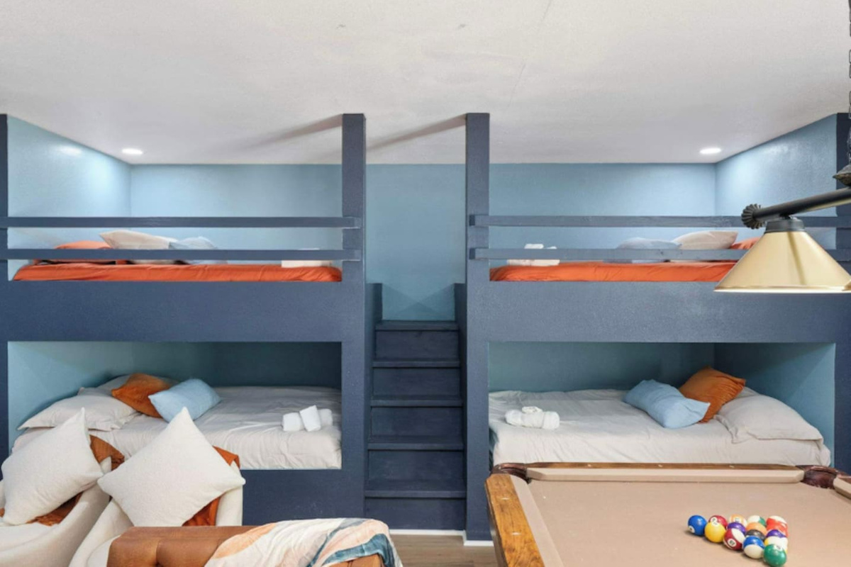 Bunk room with quad bunks, blue walls, and orange accents—sleeps up to eight guests comfortably for large groups.
