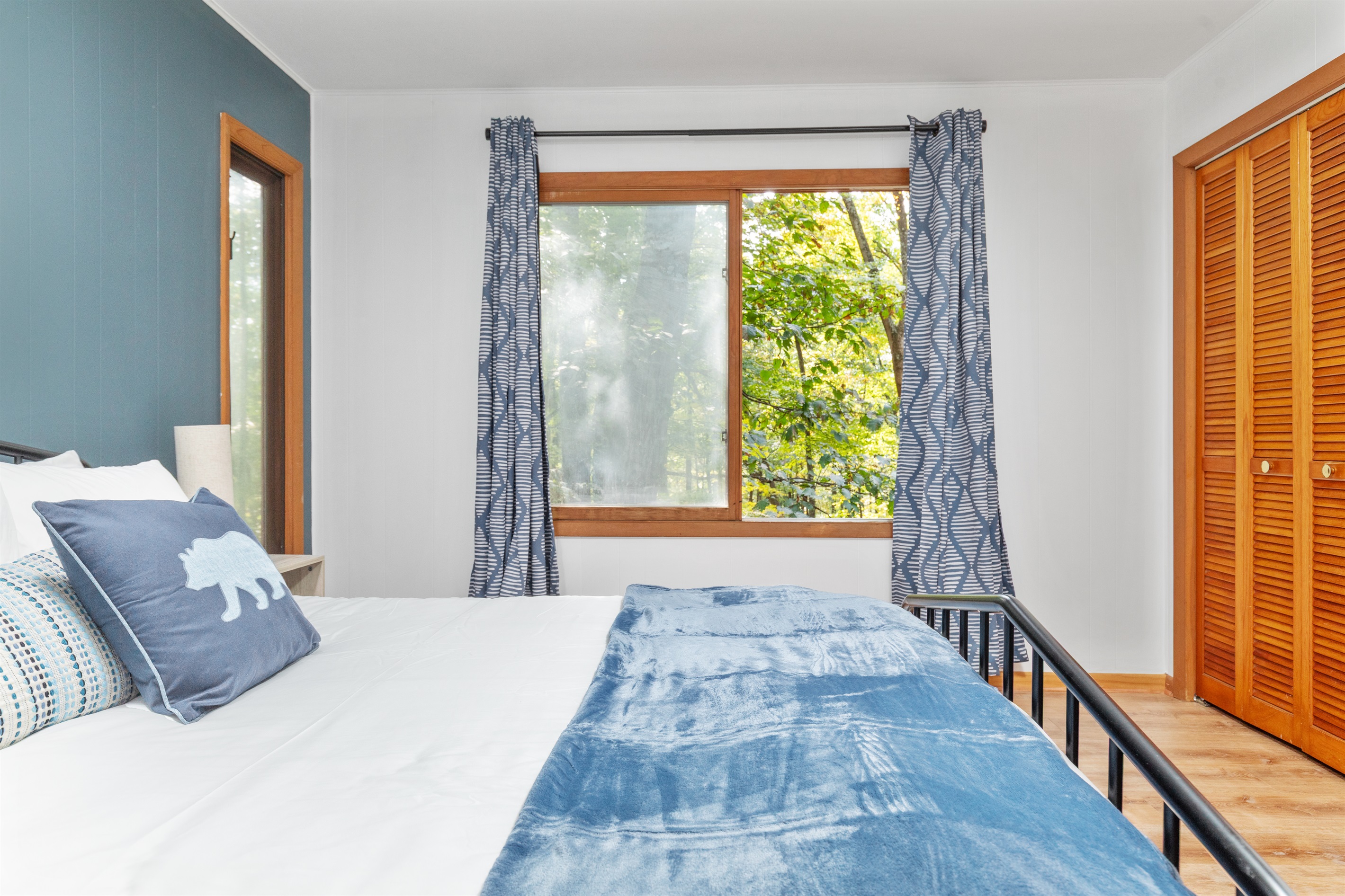 Comfort meets nature: queen bed with beautiful forest views, perfect for relaxing and reading