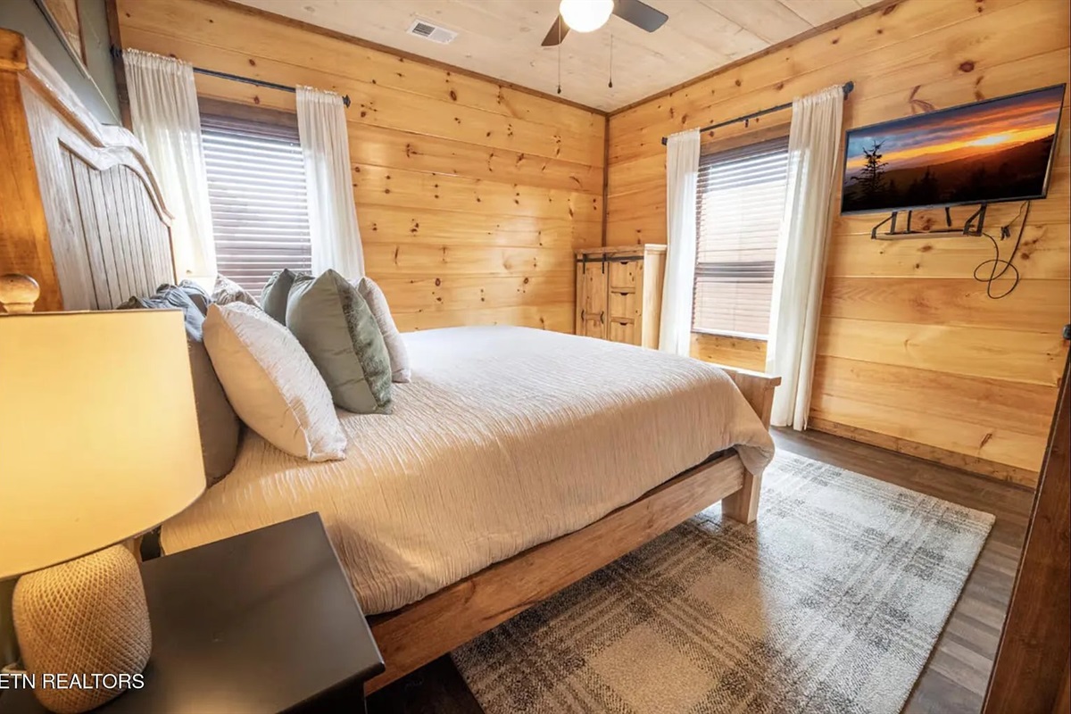 A closer look at the thoughtful touches in King Bedroom 2 at Marigold Cabin &mdash; comfortable bedding, warm lighting, and cabin-chic design that makes guests feel right at home. This detail view highlights the quality and care that sets Marigold apart.