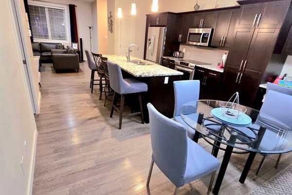 Modern open-plan kitchen, island seating, dining for 4, cozy lounge.