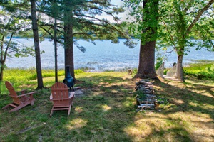 Chimnea and chairs facing the lake behind the log cabin