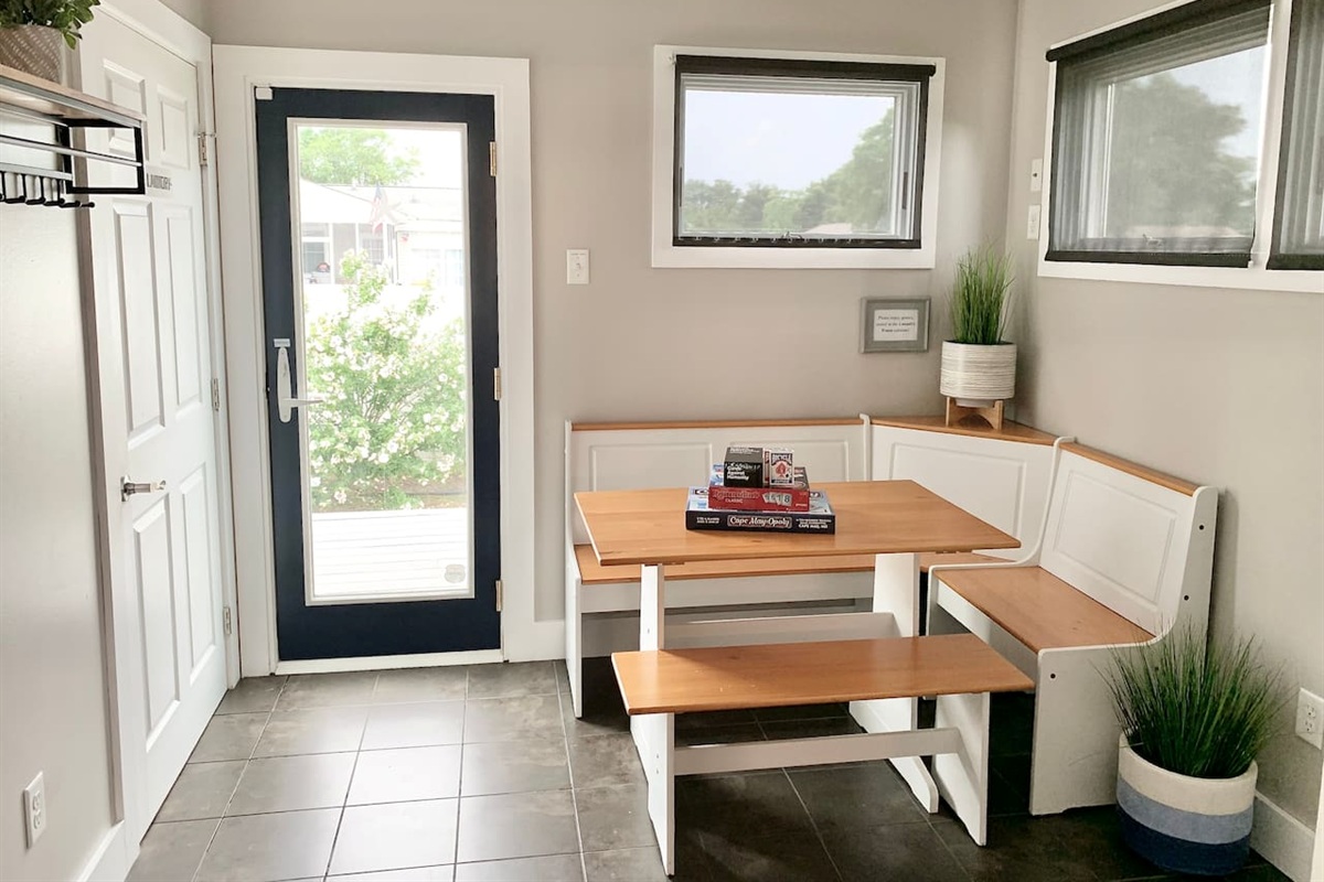 This sun-drenched breakfast nook features white corner bench seating and a light wood table. It’s the perfect spot to enjoy your morning coffee or play a board game while looking out at the yard.