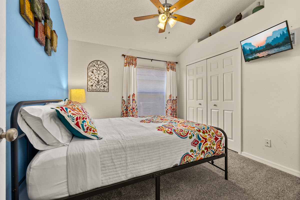Wall mounted TV and closet in the queen suite.