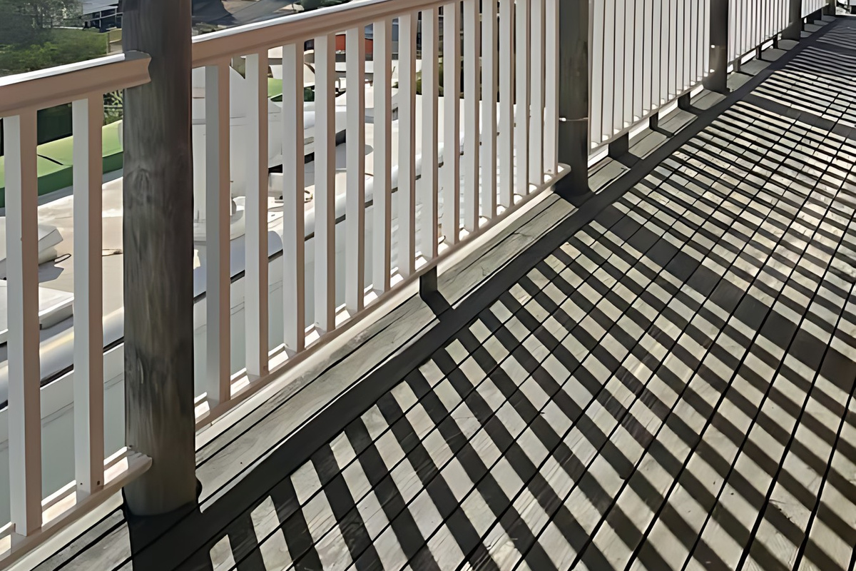 A long covered veranda runs along the house, with timber decking and white railings looking out over Preston Beach to Lake Preston and the Yalgorup National Park bushland beyond.