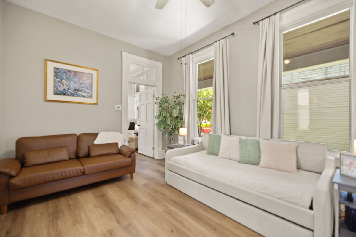 Comfortable living room with classic leather sofa, warm hardwood floors, and a comfortable twin daybed for mid-day naps with a pullout twin trundle underneath