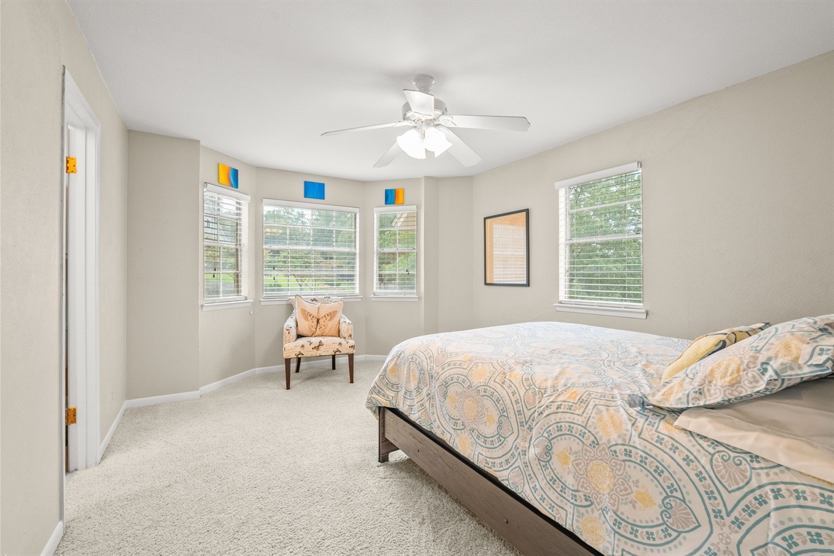 Bedroom 5 with original art and bay window.