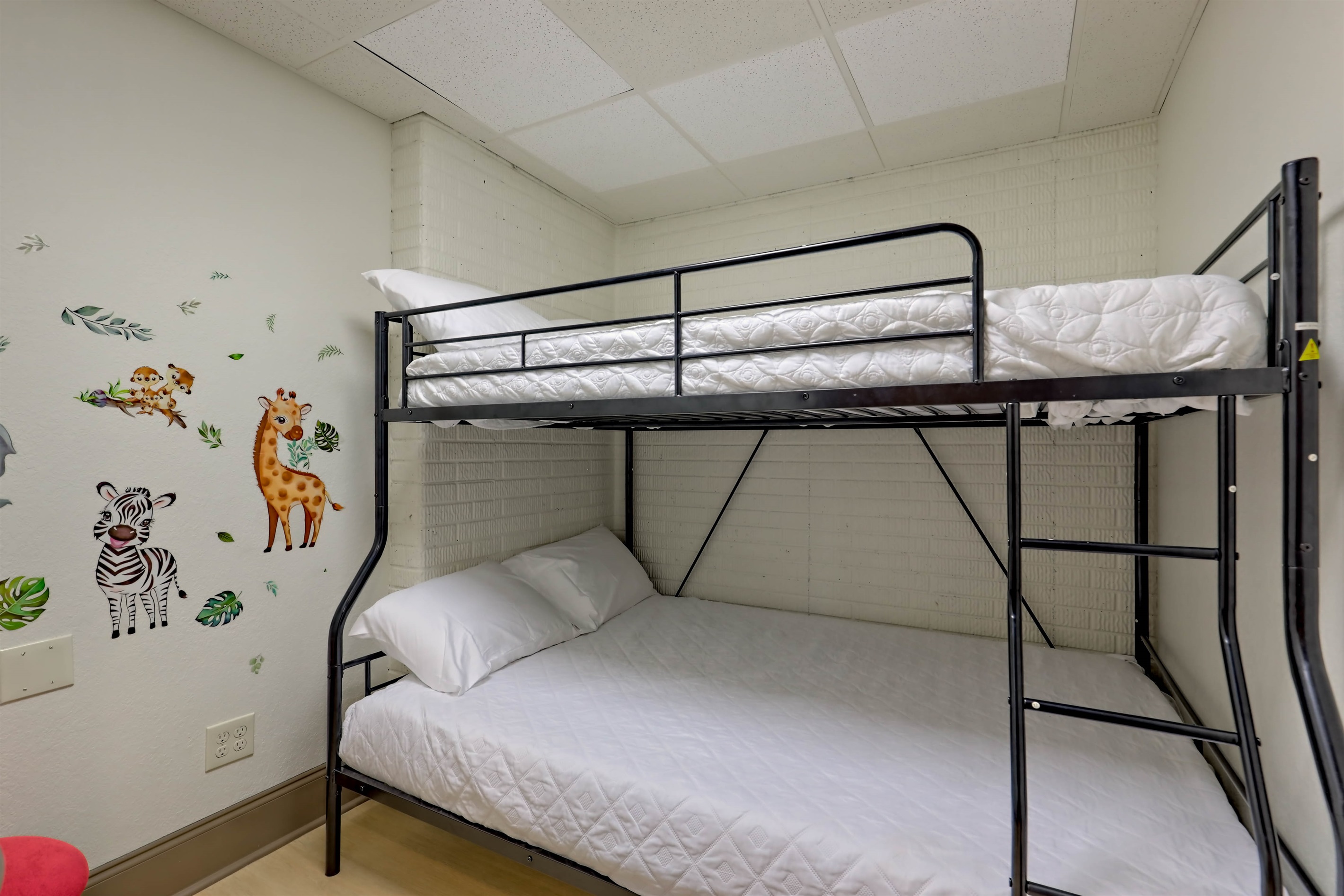 Kid-friendly bunk room with cute wall art and extra sleeping space.