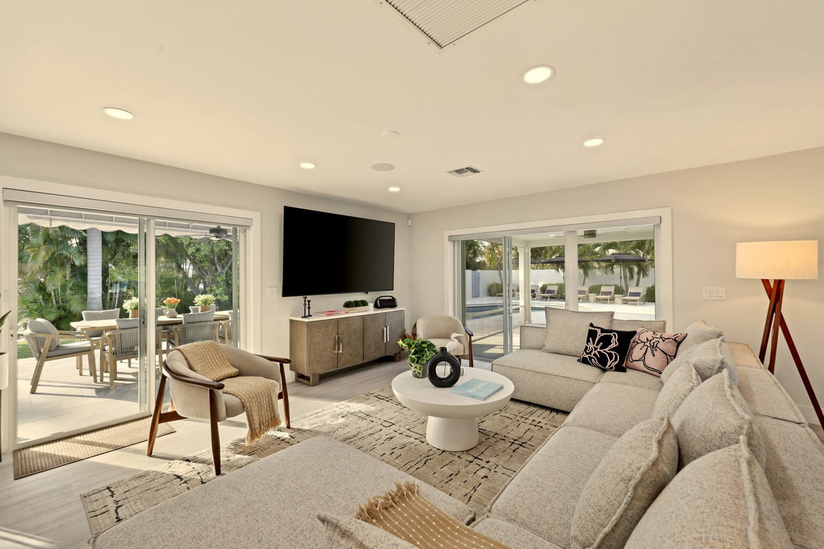 Relax in the bright living room, watch the large TV, while the pool and covered patio are in view through the wide sliding doors.