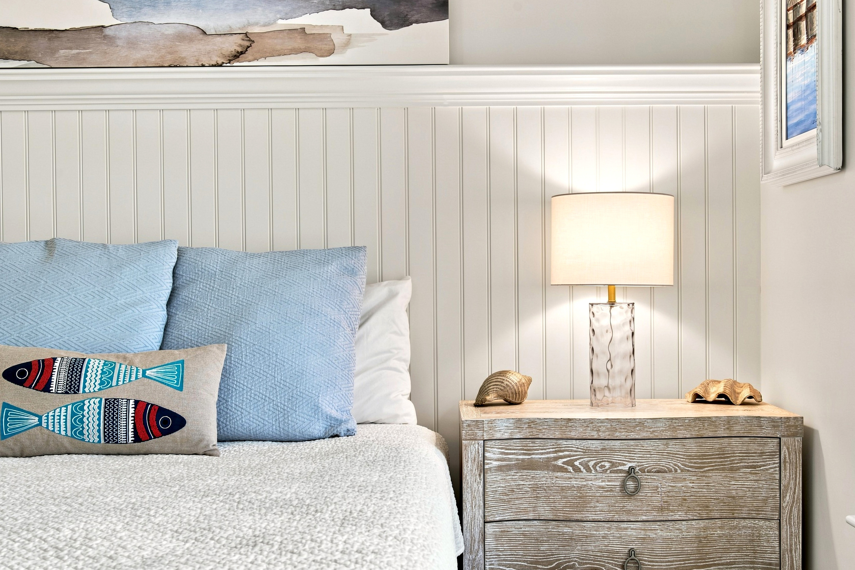 Soft coastal details and bedside lighting create a comfortable space to settle in for a restful night.