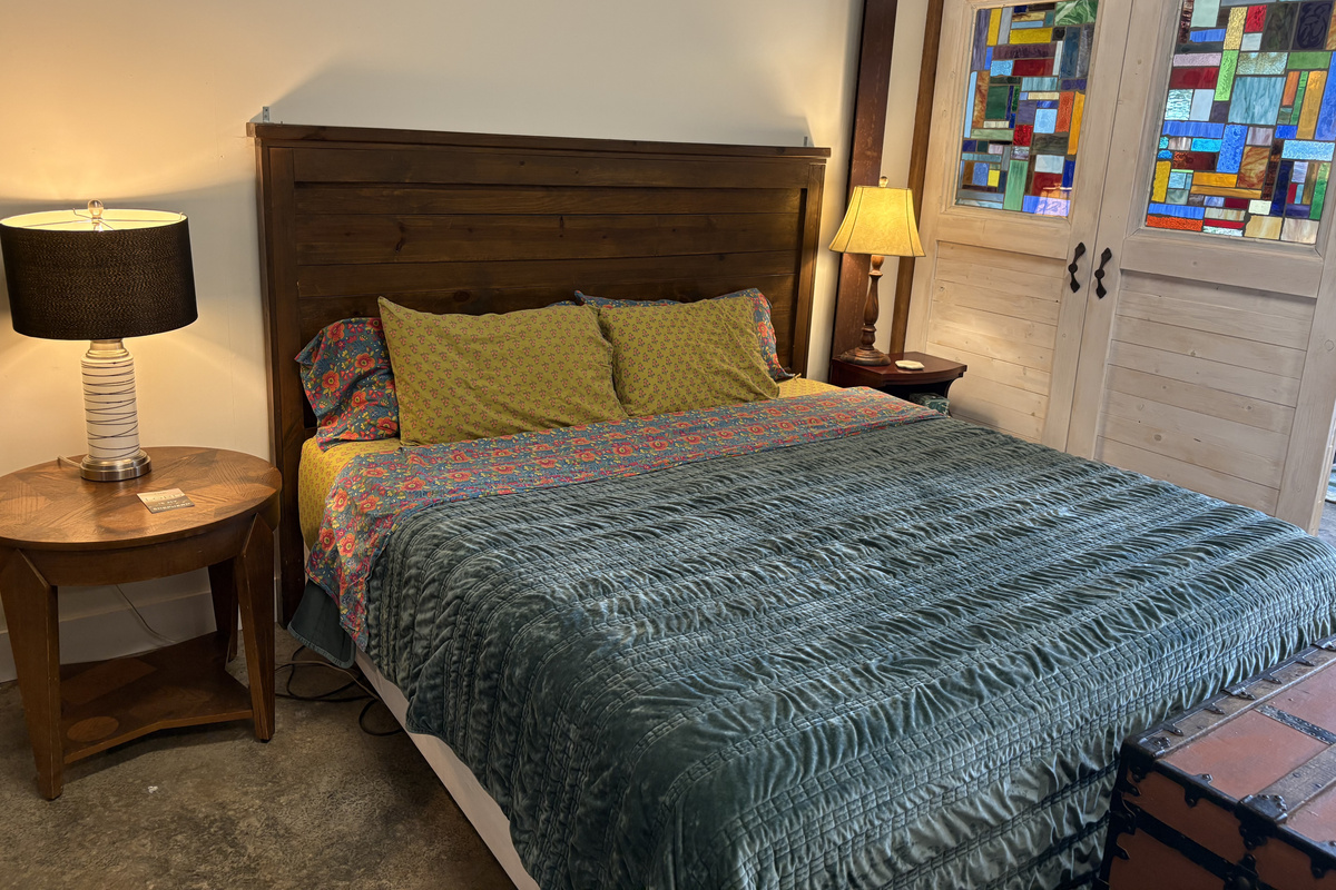 King bed next to beautiful stained glass divider 