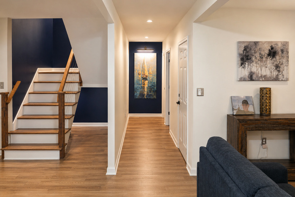 Main-floor living room with comfortable seating, warm lighting and easy access to the kitchen, dining area and upstairs loft.