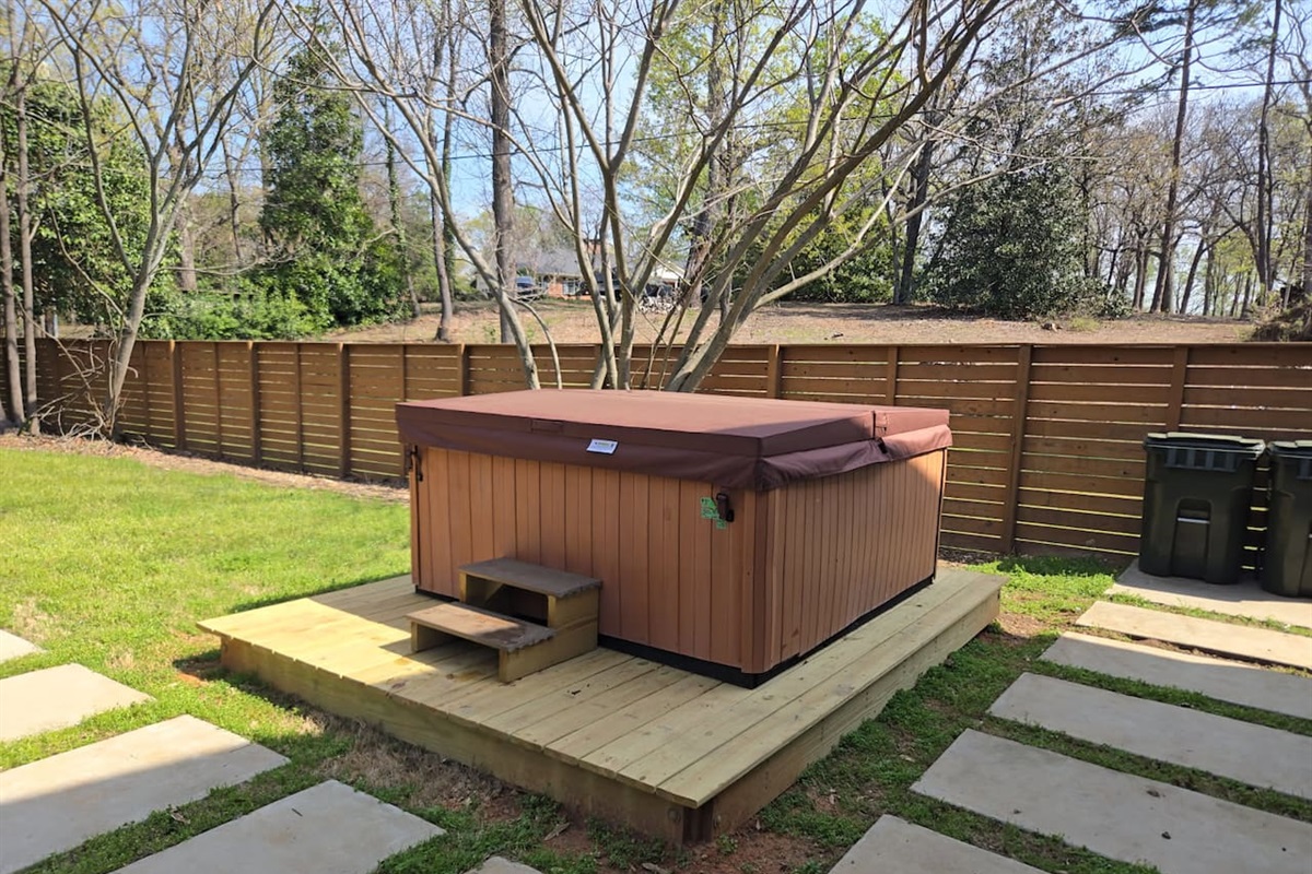 Enjoy a secluded backyard retreat featuring a premium hot tub, private deck, and peaceful surroundings—your perfect escape in Greenville.