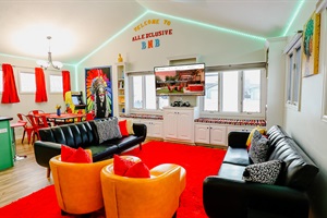 A vibrant orange couch paired with a sleek black couch, creating a bold and stylish seating arrangement that stands out in any living space.
