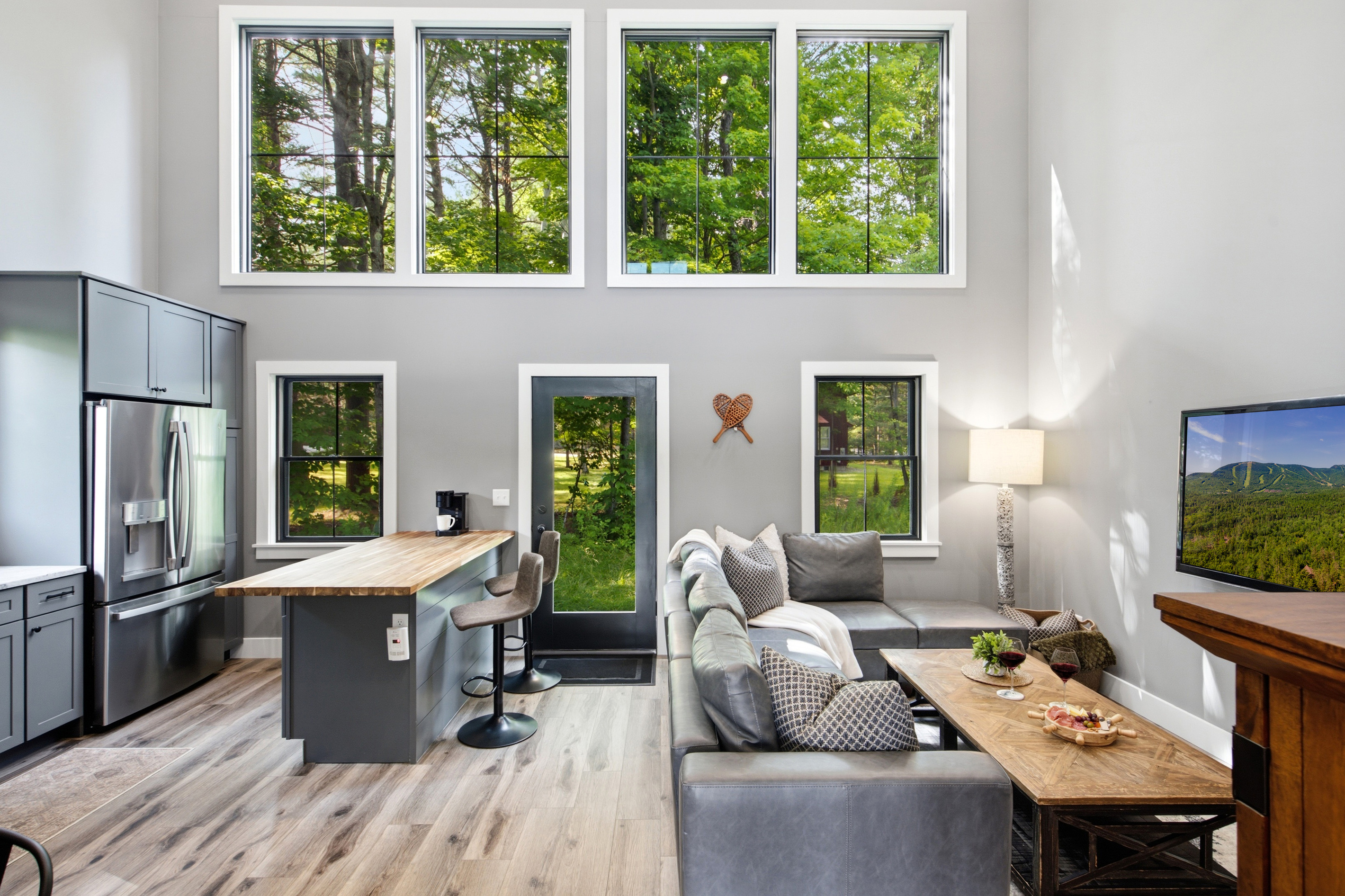 Soaring windows and an open layout create a bright, airy space surrounded by beautiful forest views.