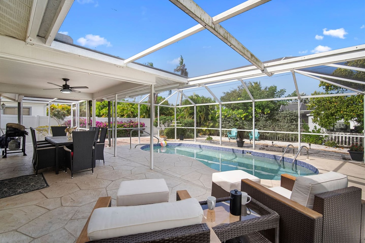 Launge chairs, pool, dining table, and the grill on the creened lanai