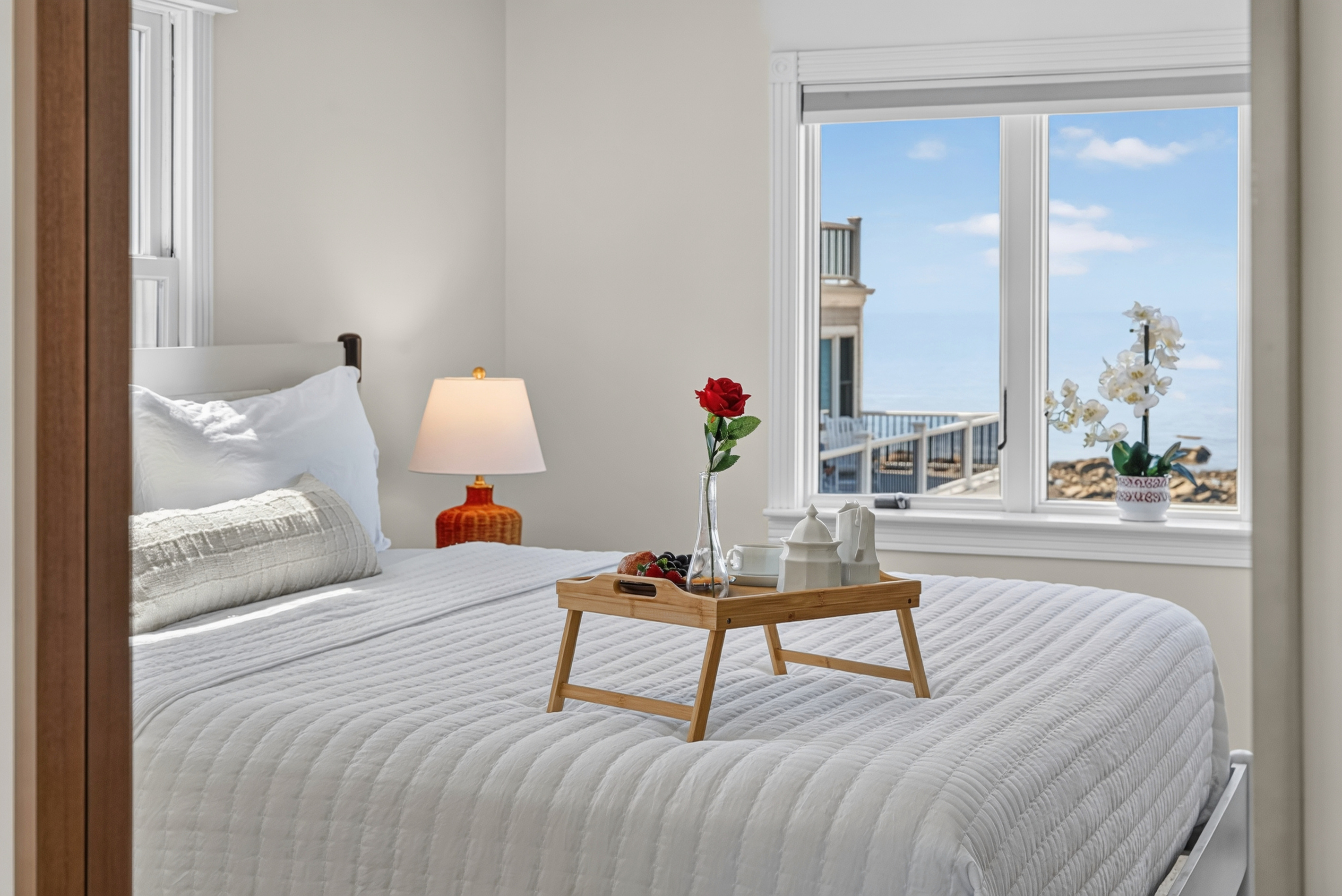 Spacious bedroom with large windows offering abundant natural light and relaxing views.
