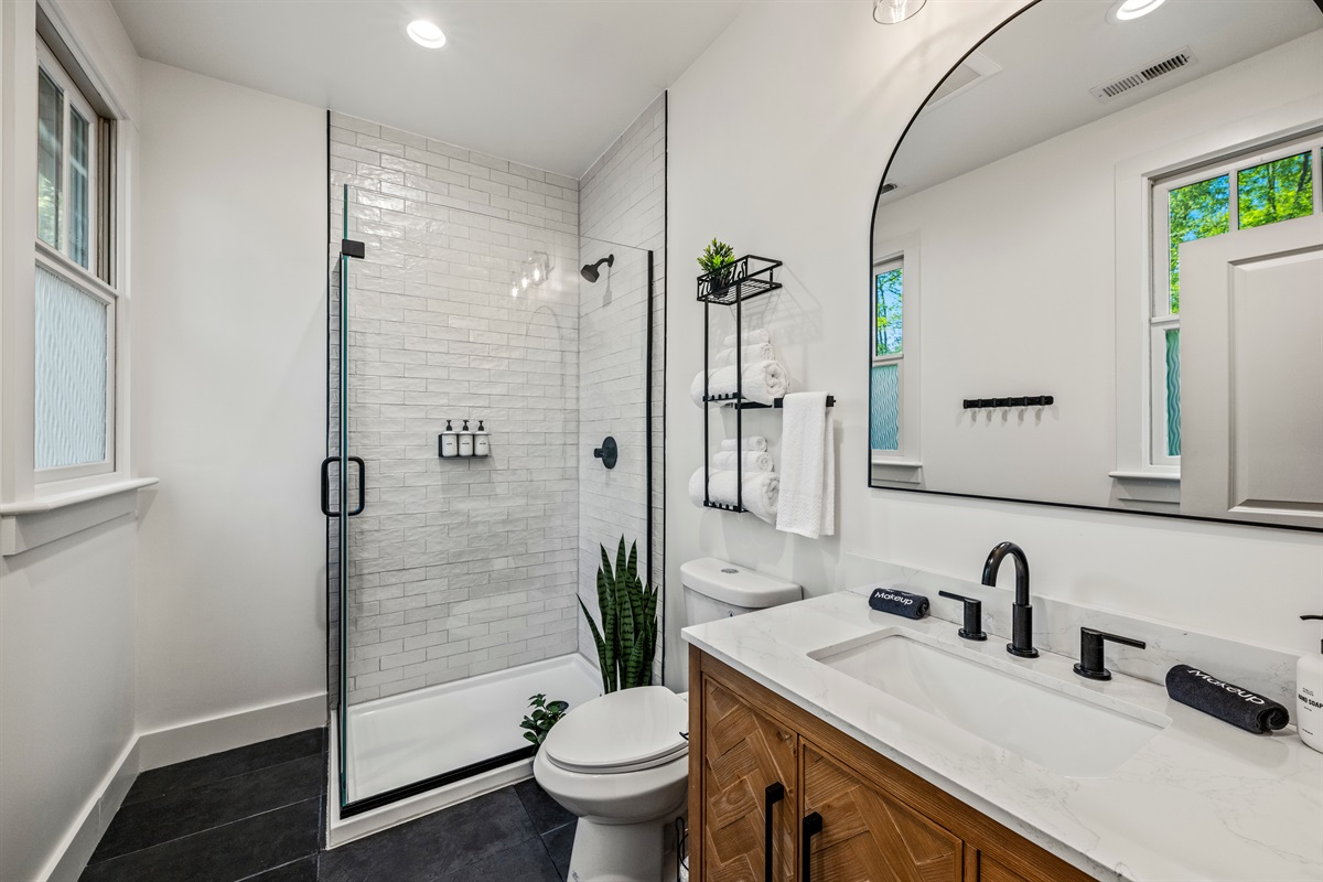 Bright and crisp, this modern bathroom features a sleek white tile shower and matte black accents for a clean, stylish finish.